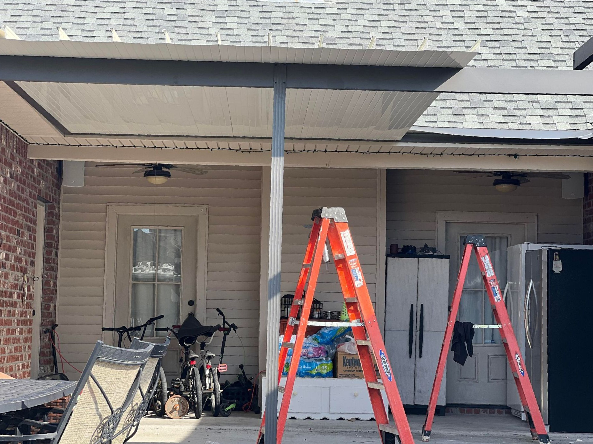 Two ladders are sitting in front of a house.