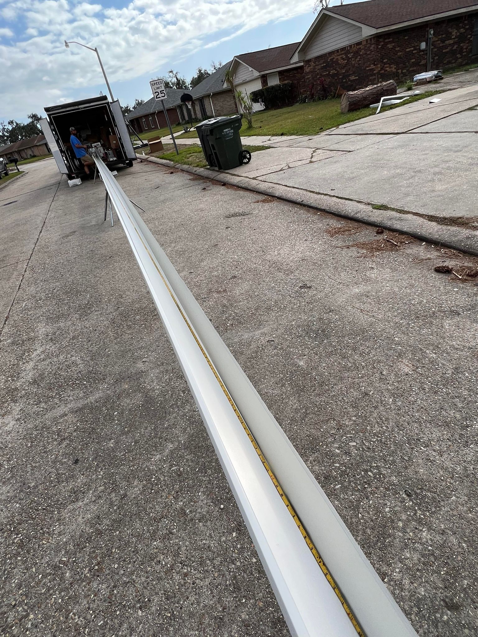 A white pipe is sitting on the side of the road next to a truck.