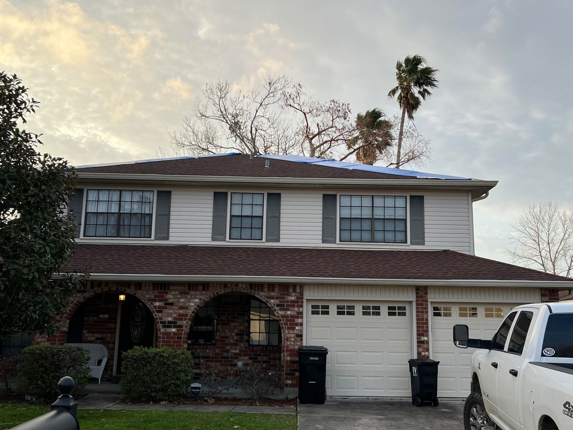 A white truck is parked in front of a house.