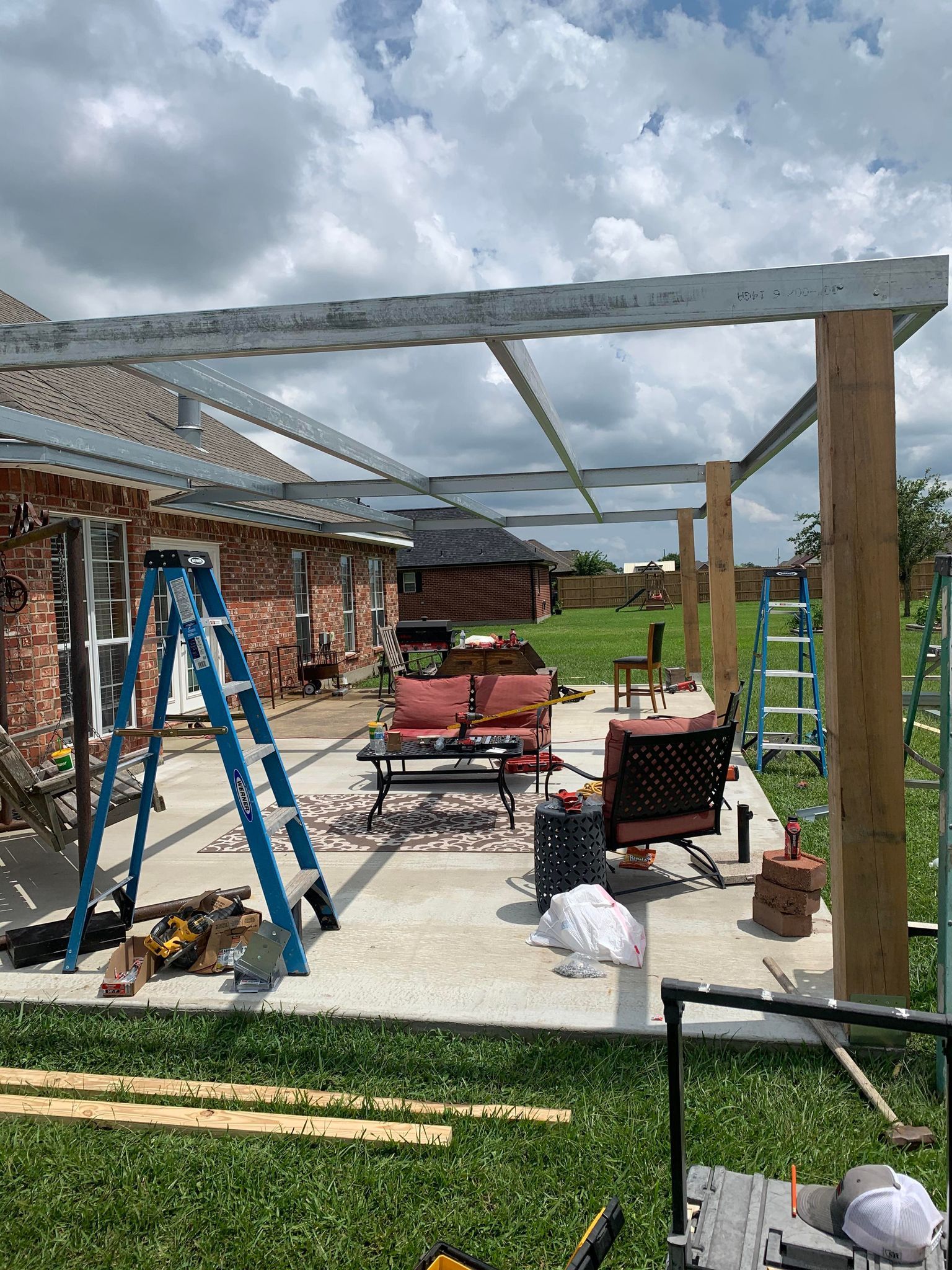 A pergola is being built in the backyard of a house.