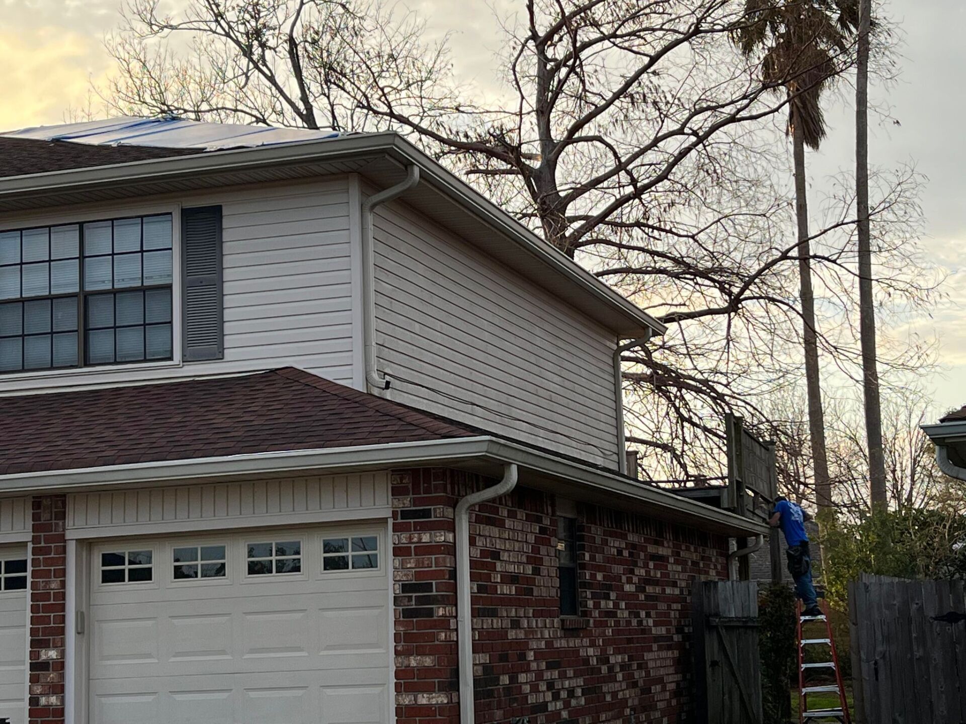 A man is working on the roof of a house.