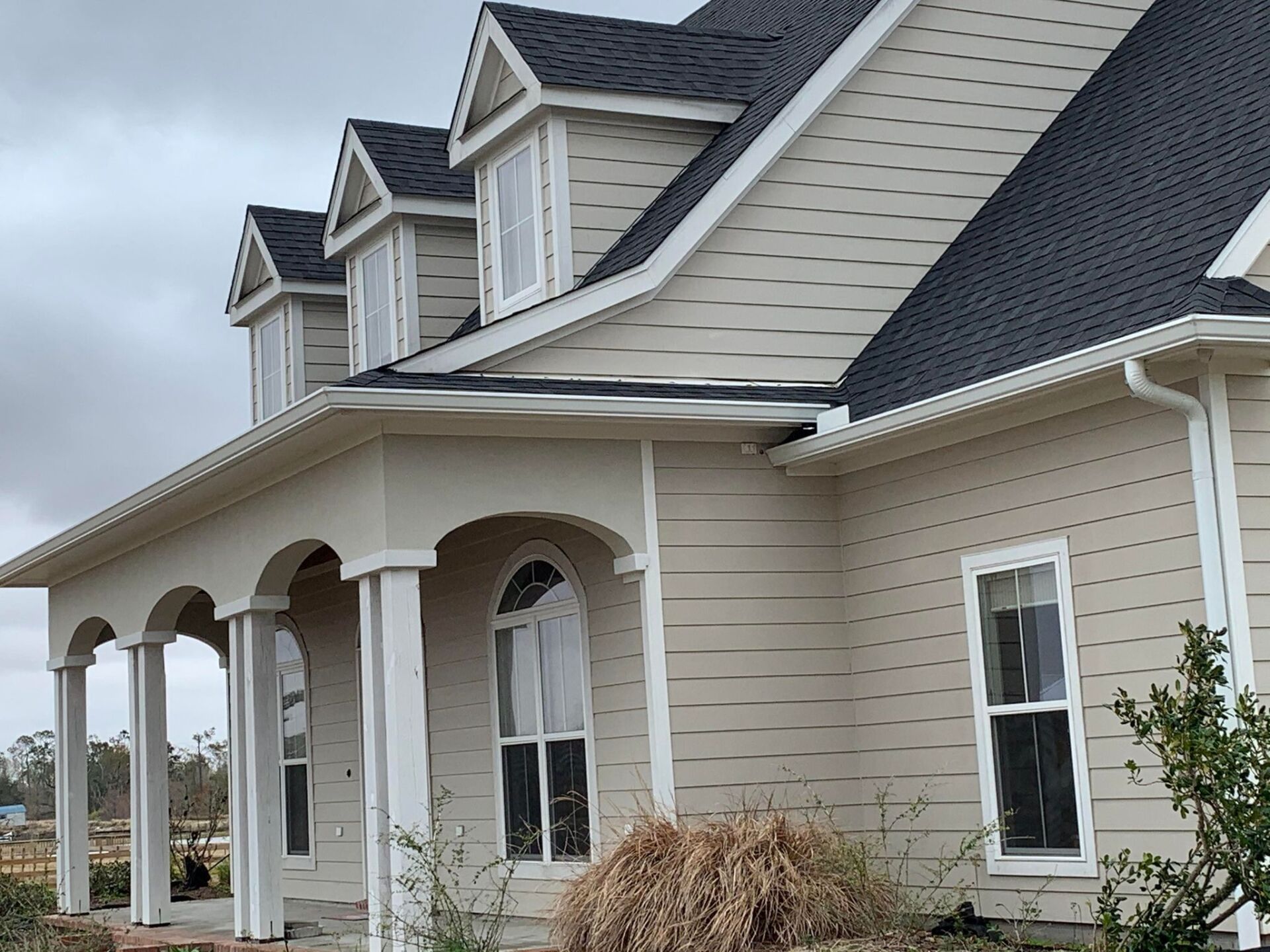 A large house with a porch and a black roof