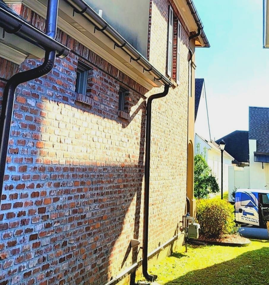 A brick building with a gutter on the side of it