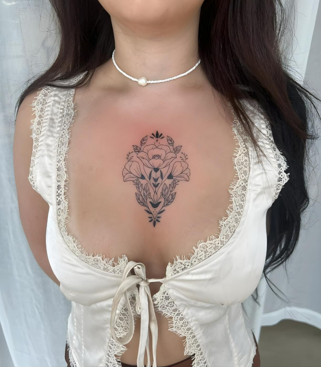 Woman in white lace top with floral chest tattoo, pearl choker — Tattoo Inc Studio In Broadbeach, QLD