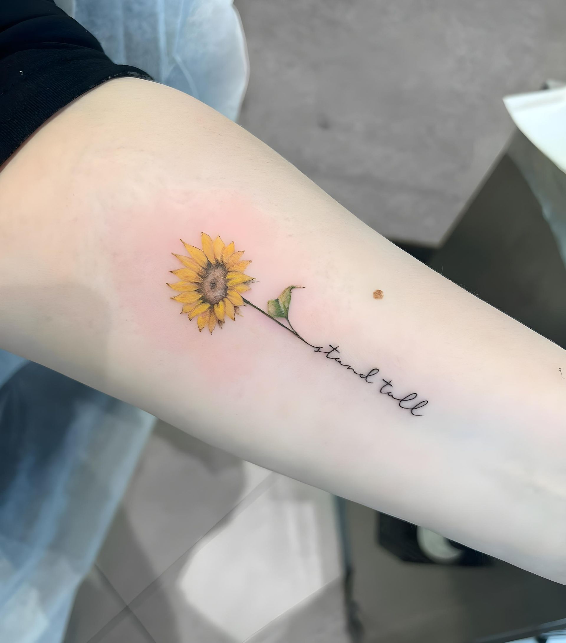 A Woman is Getting a Tattoo on Her Arm — Tattoo Inc Studio in Robina, QLD