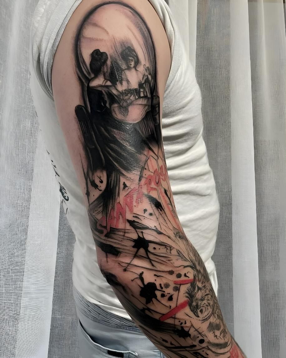 Man's arm tattoo featuring a skull at the shoulder with abstract black and red splatters down the forearm — Tattoo Inc Studio In Broadbeach, QLD