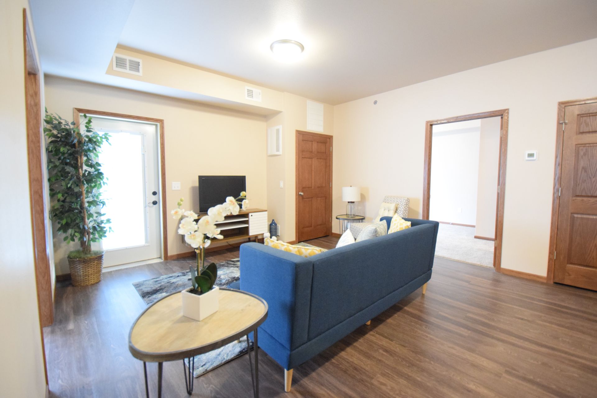a living room with a blue couch and a flat screen tv