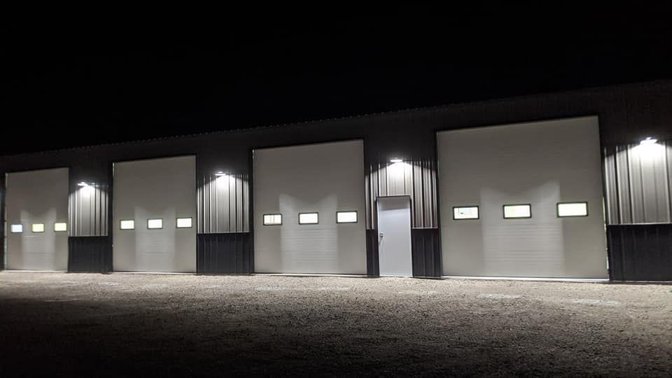 A row of garage doors are lit up at night.