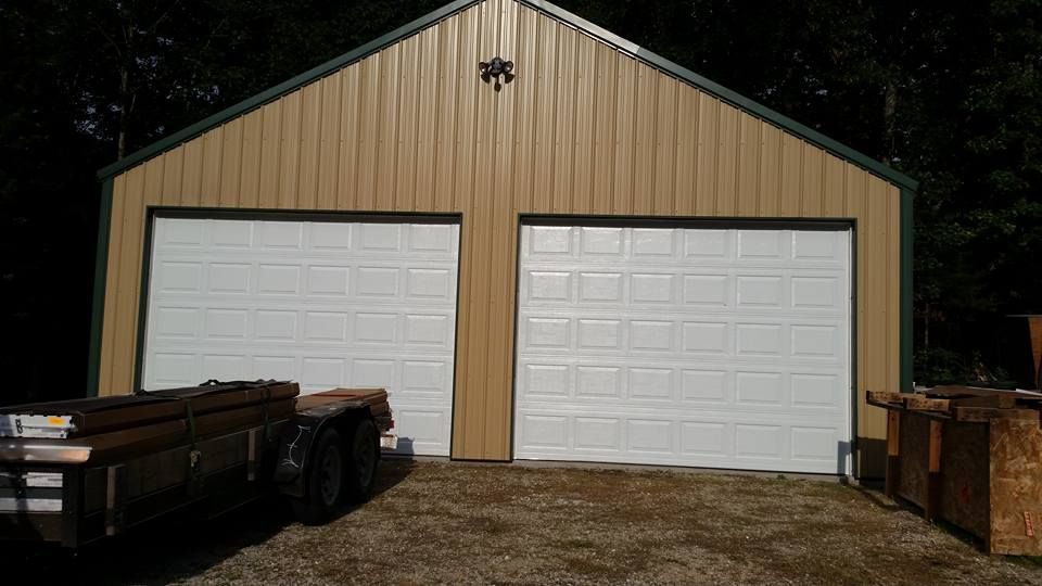 A garage with two garage doors and a truck parked in front of it.