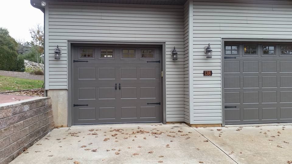 There are two garage doors on the side of a house.
