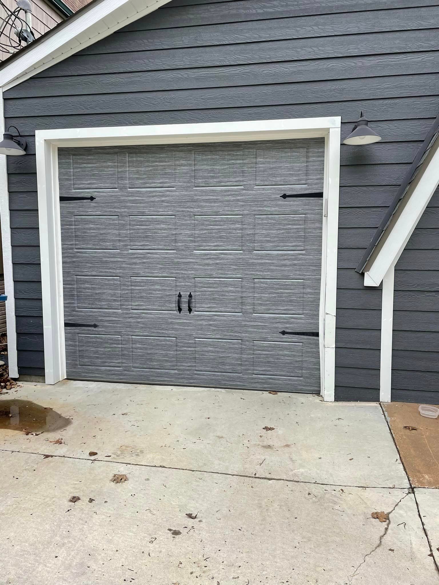 A garage door is being installed on the side of a house.