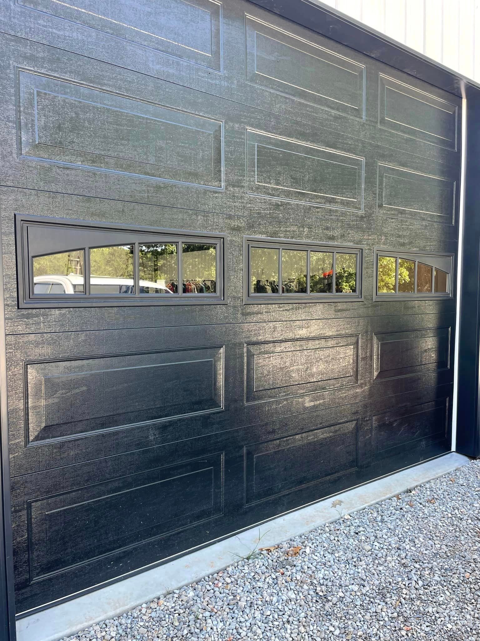 A black garage door with a lot of windows on it.