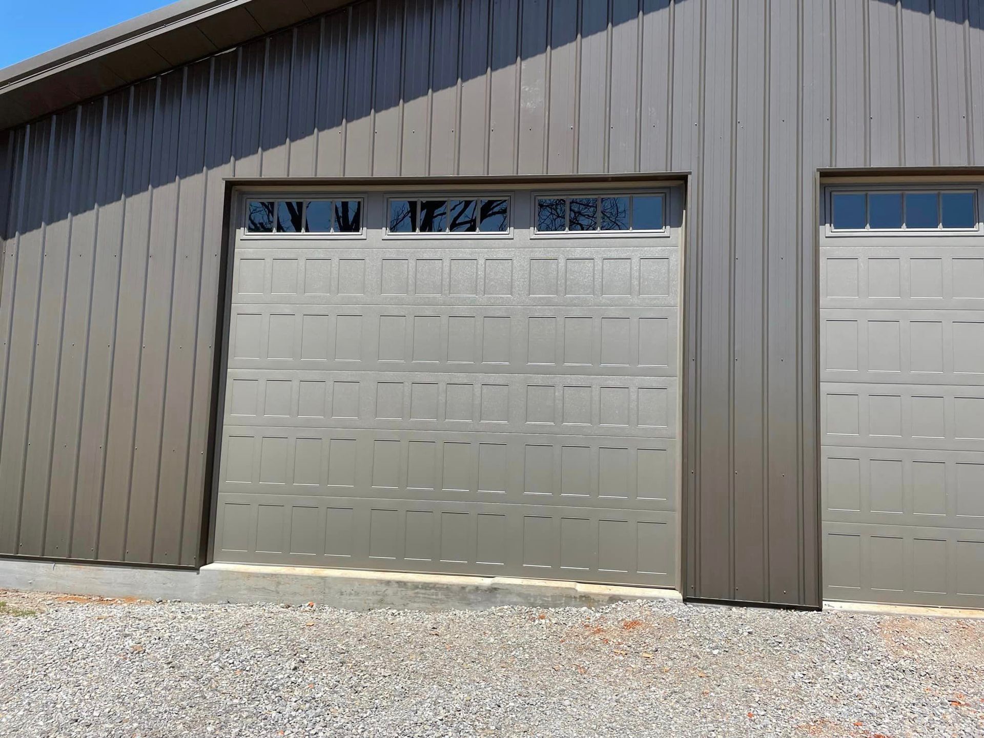 There are two garage doors on the side of a building.