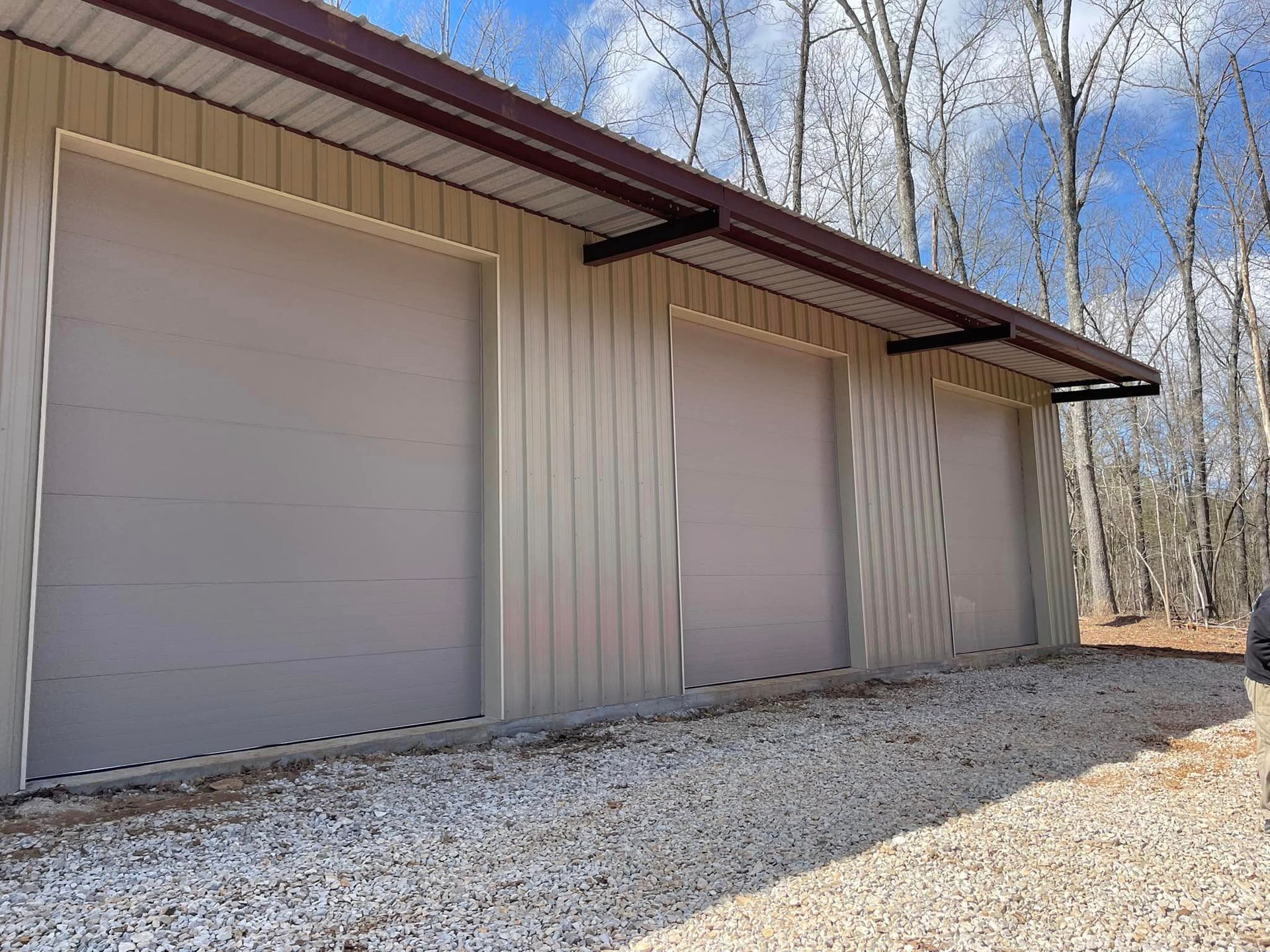 There are three garage doors on the side of a building.