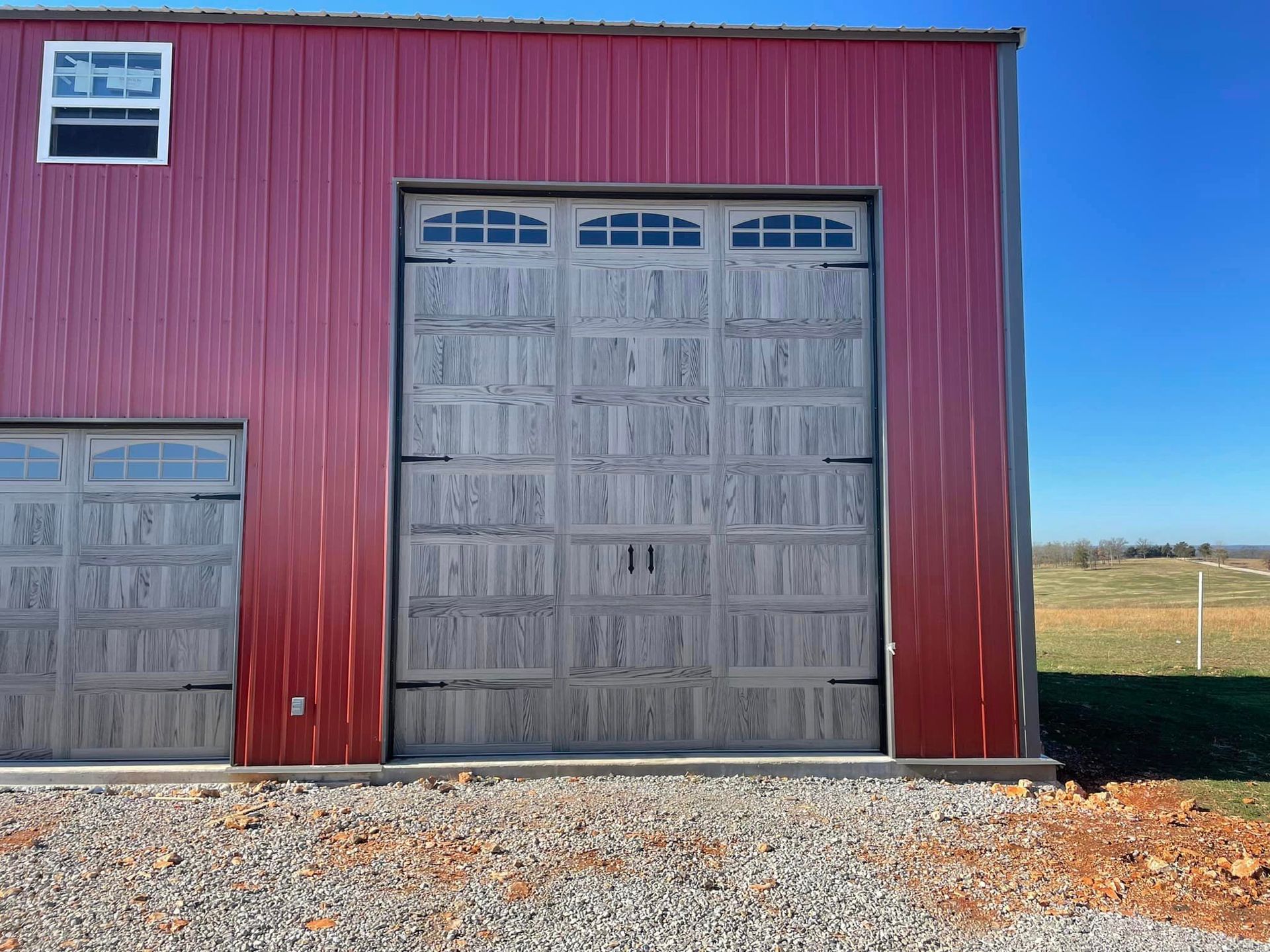 A red building with a large garage door and a window.