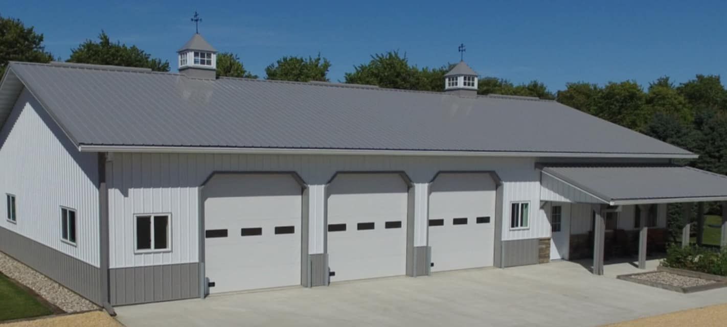 A large white and gray building with four garage doors