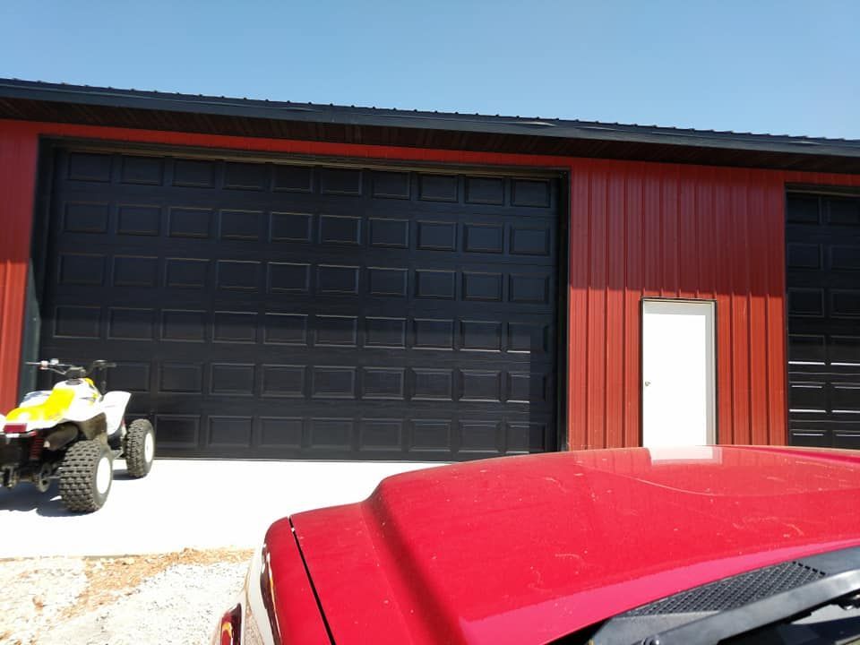 A red truck is parked in front of a garage door