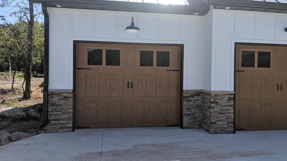 There are two garage doors on the side of a house.