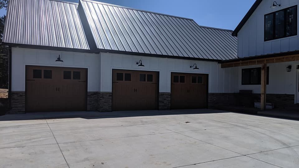 A house with three garage doors and a metal roof
