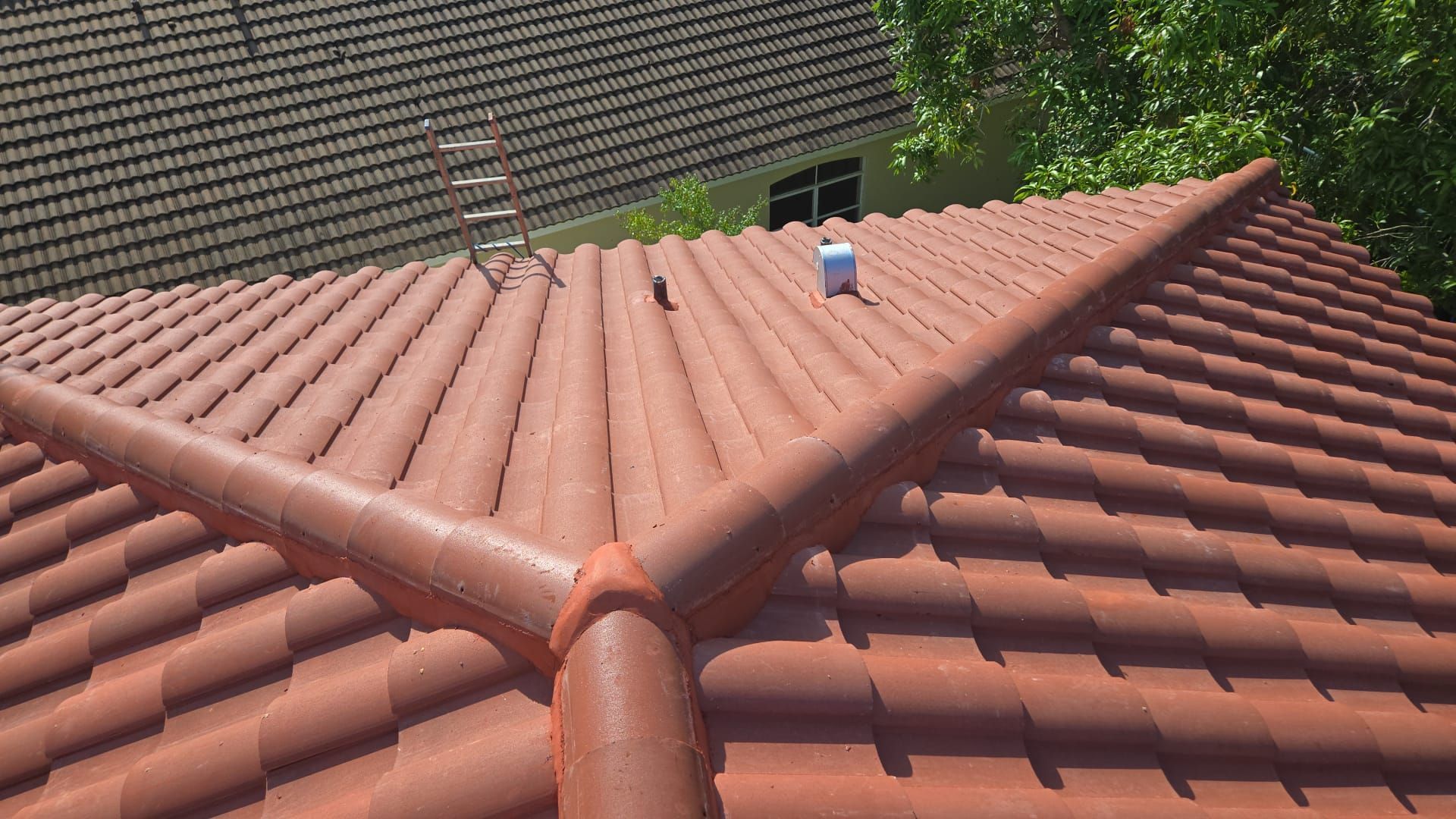 Red tile roof with ridge capping, viewed from an angle.