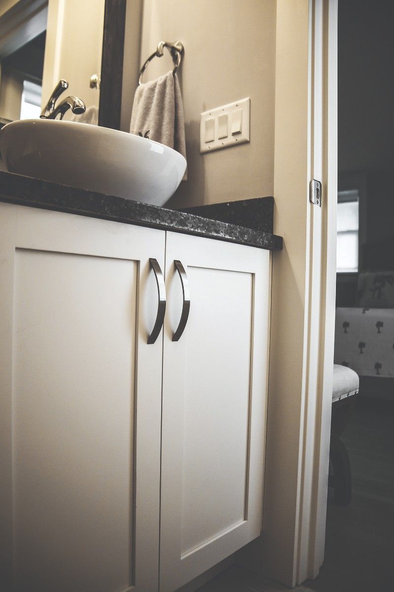 A bathroom with white cabinets and a sink