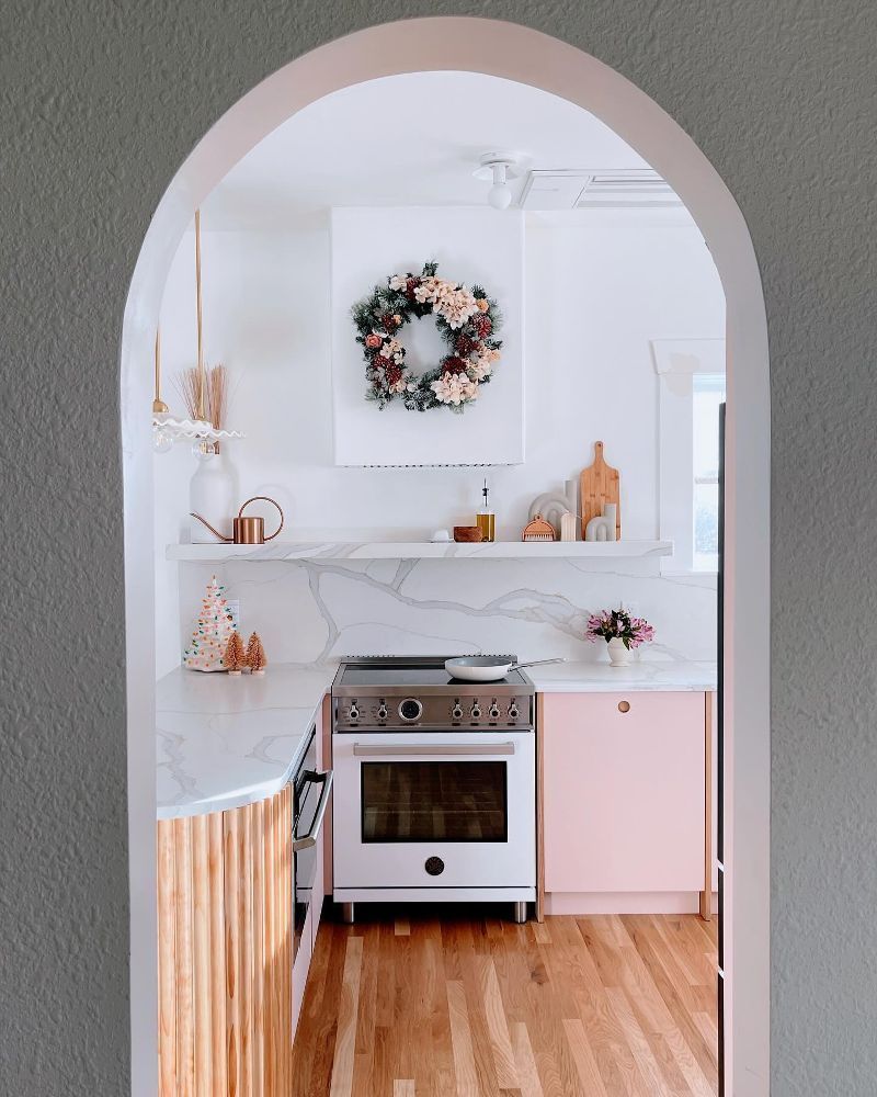 A kitchen with a wreath on the wall above the stove