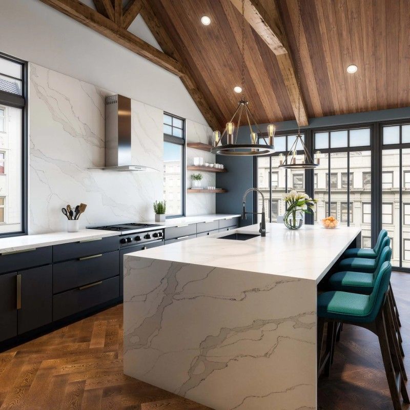 A kitchen with a large island and lots of windows