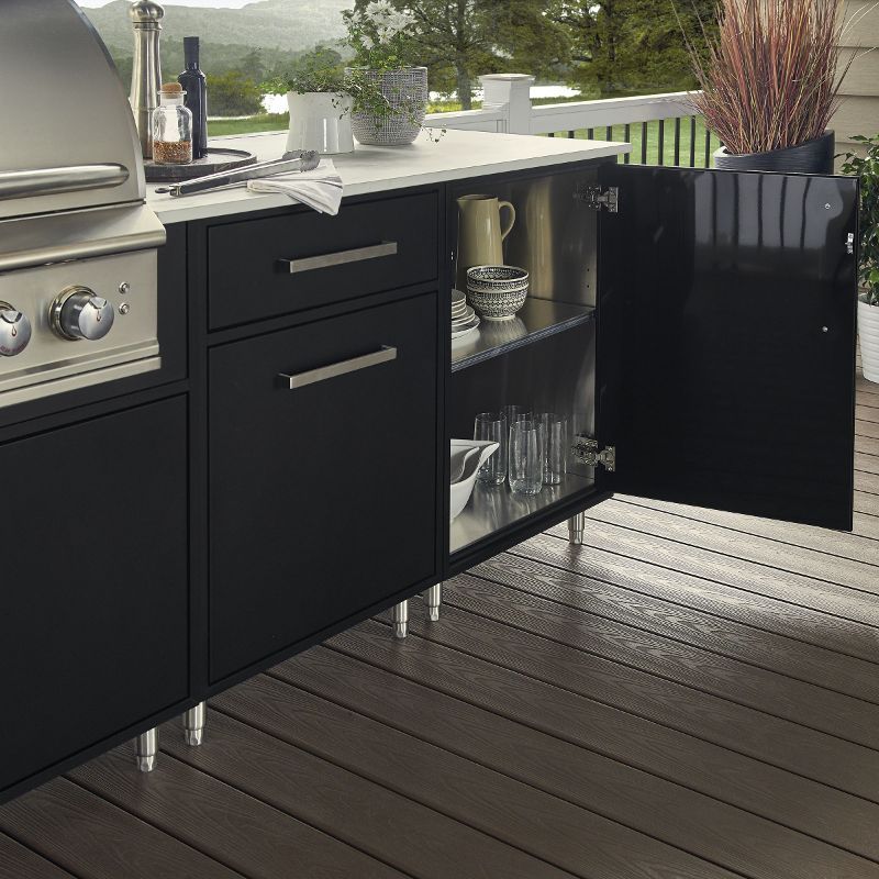An outdoor kitchen with black cabinets and a grill