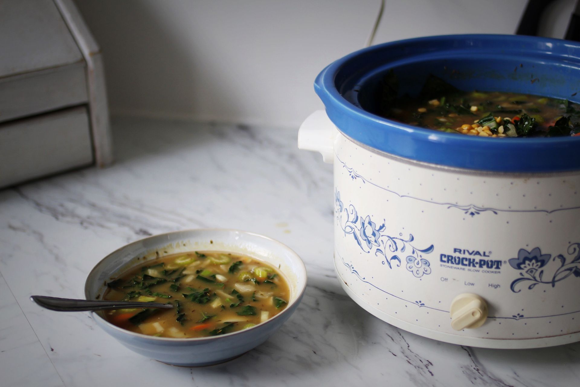 bowl of soup next to crockpot with soup in it