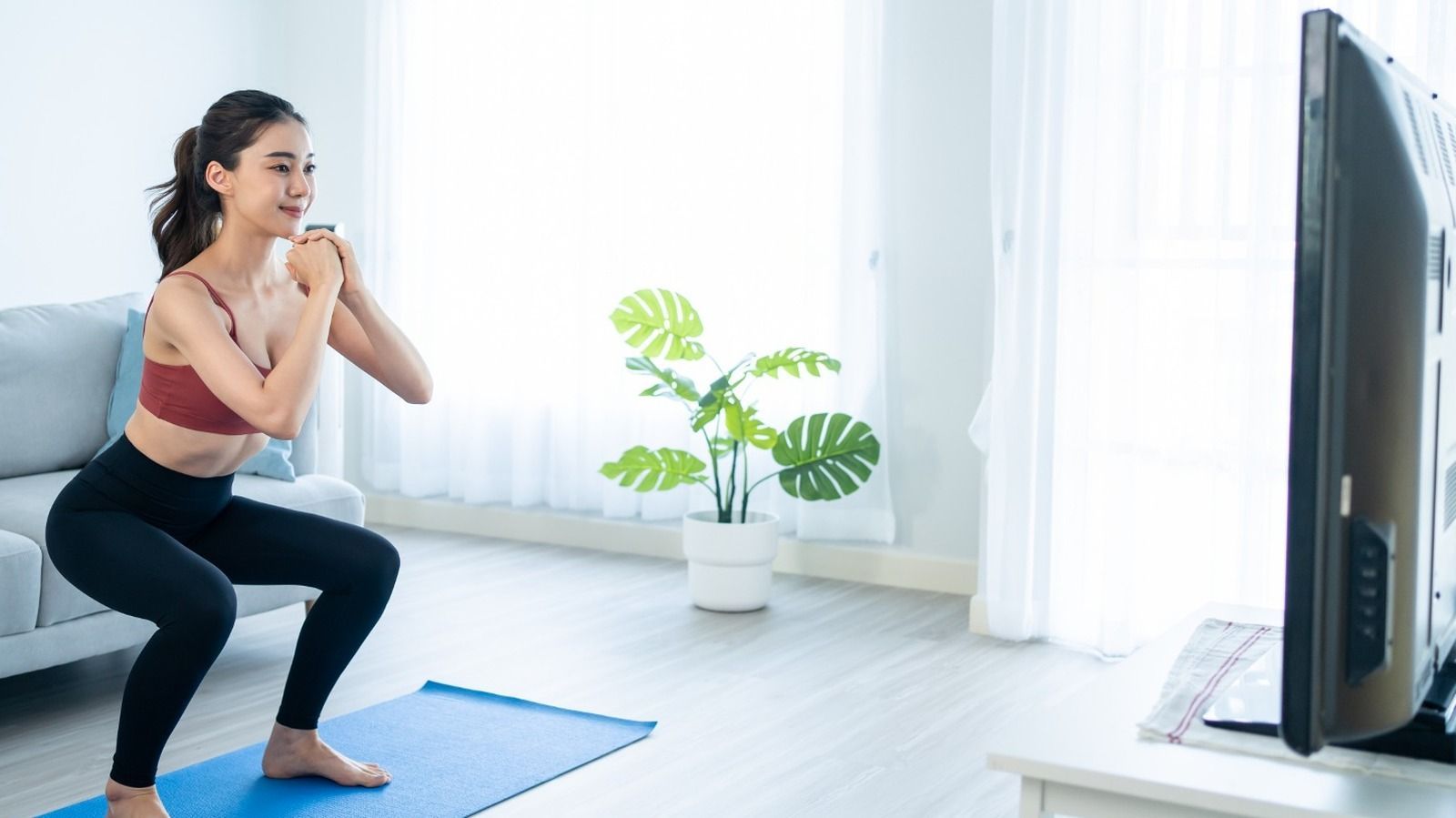 woman doing yoga while watching TV