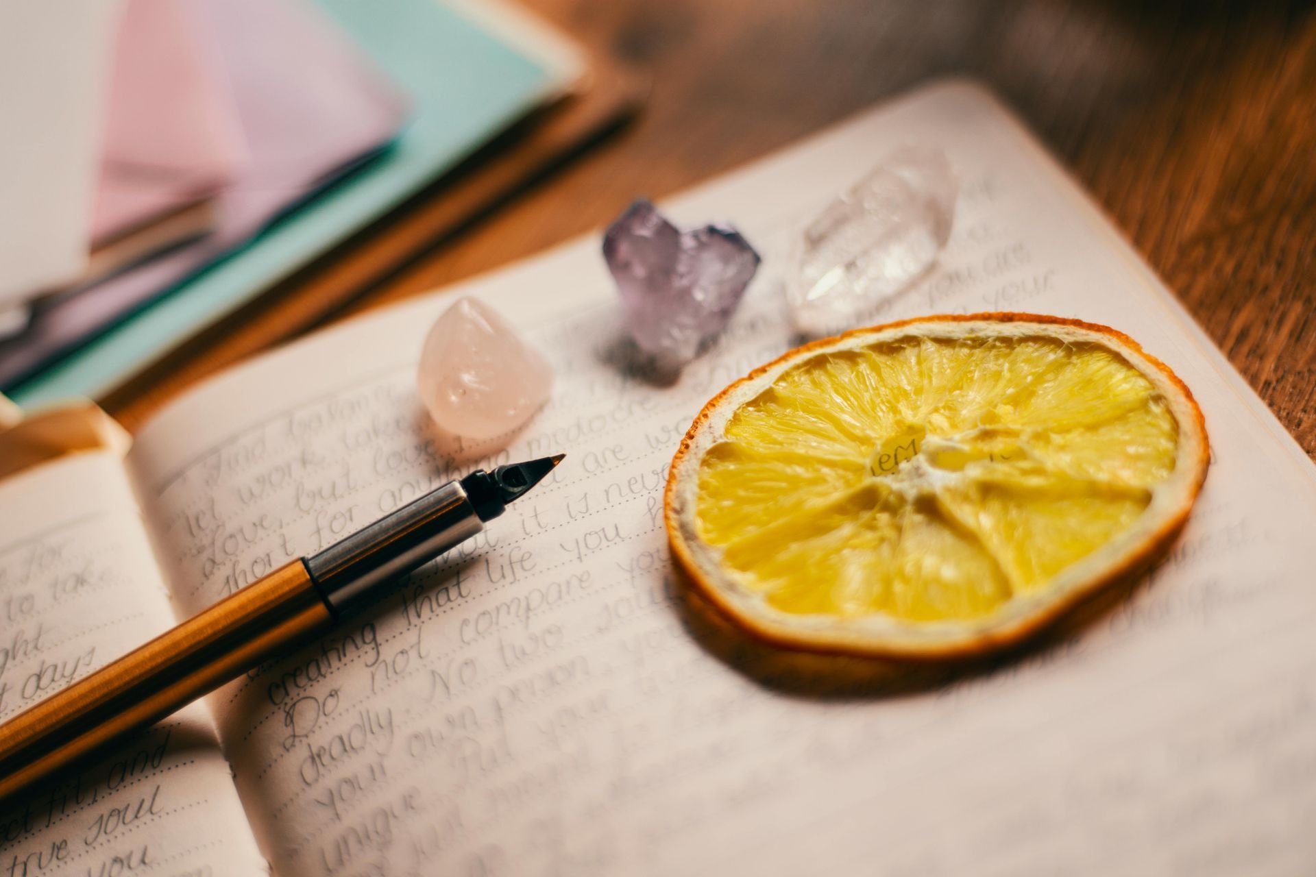Dried orange slice, crystals, and a pen on a journal page