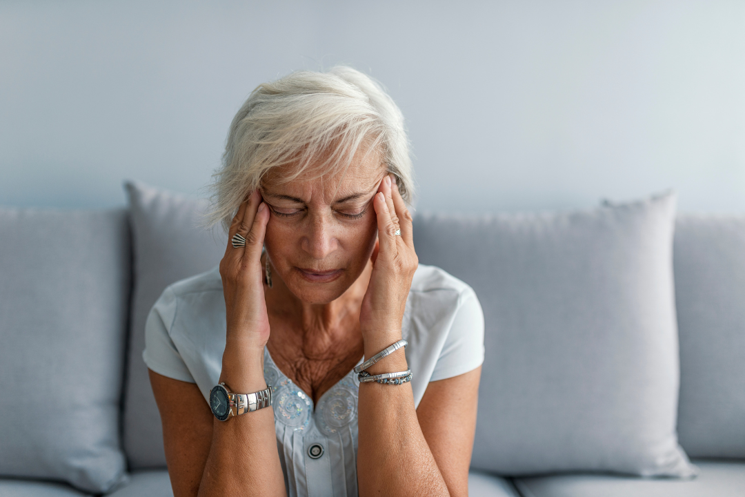 older woman holding her head in pain