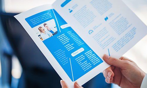 Hands holding a brochure