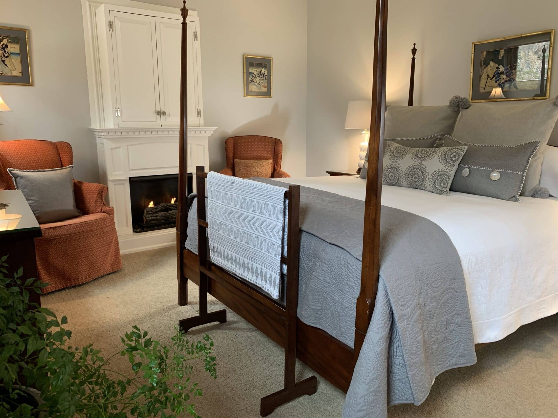 A bedroom with a four poster bed and a fireplace.