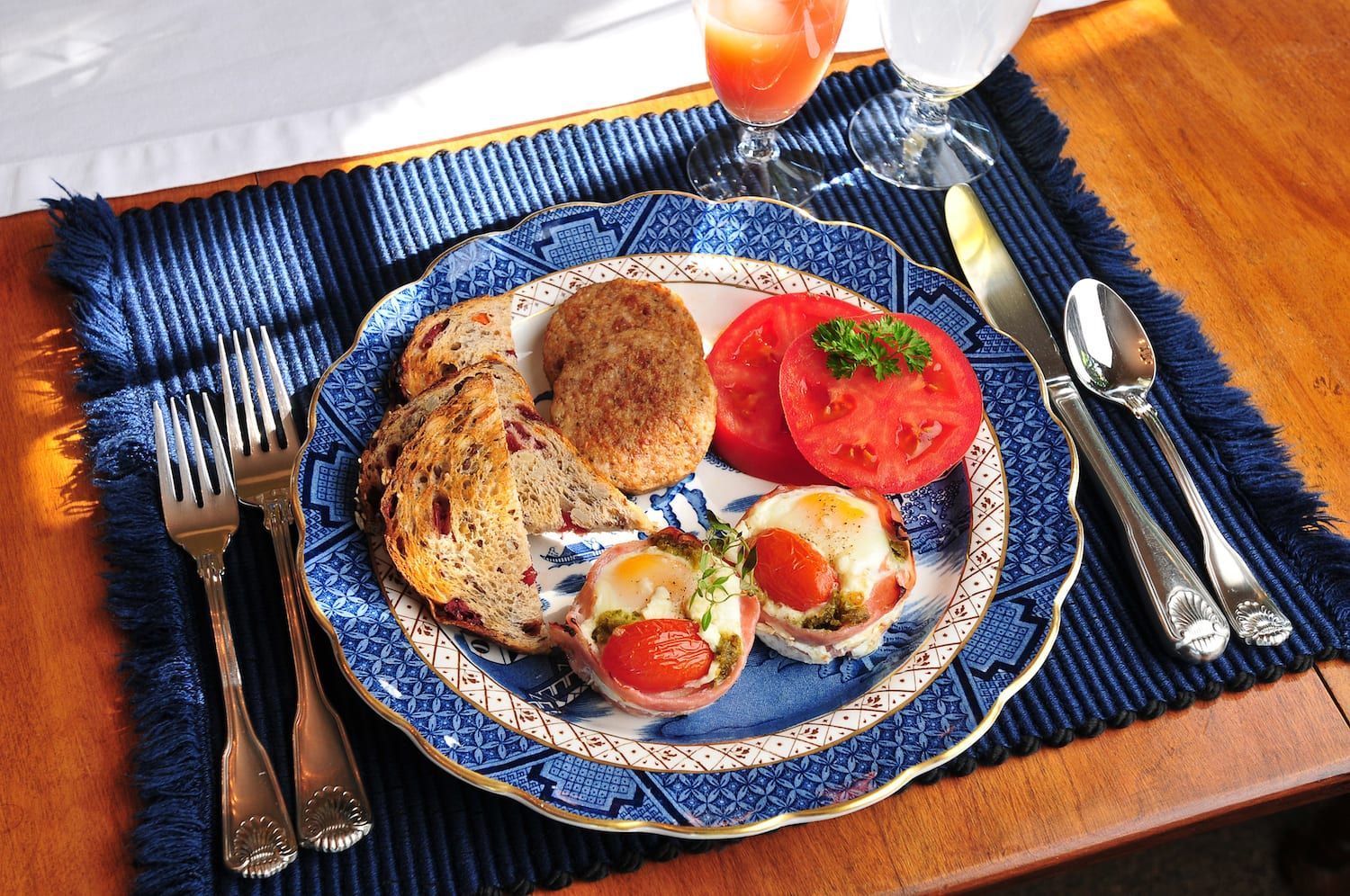 A plate of food on a table with a glass of orange juice