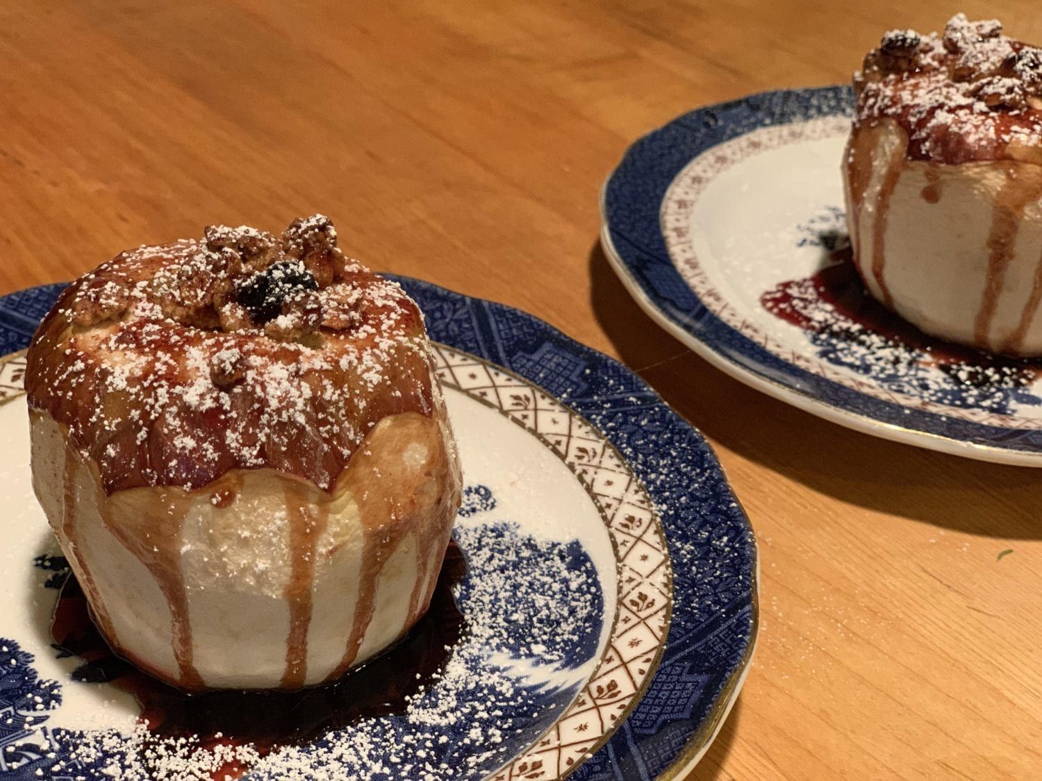 Two plates with stuffed apples on them on a table