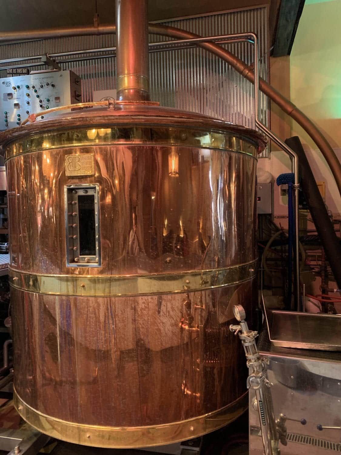 A large copper barrel is sitting in a room.