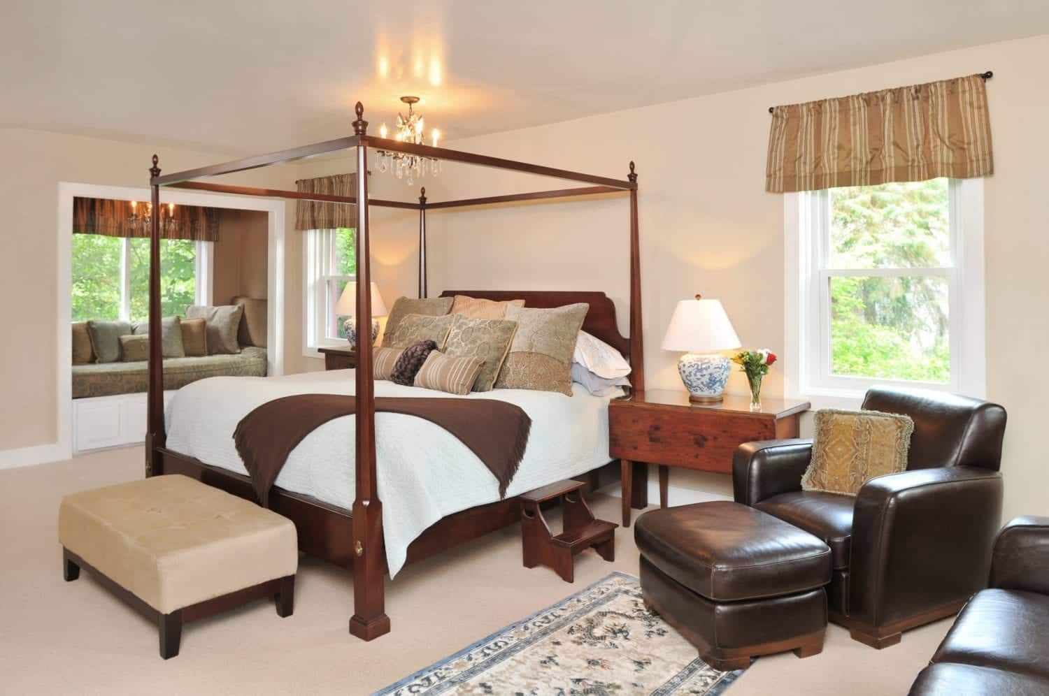 A bedroom with a four poster bed and a couch