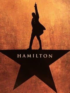 A silhouette of a man standing on top of a hamilton star