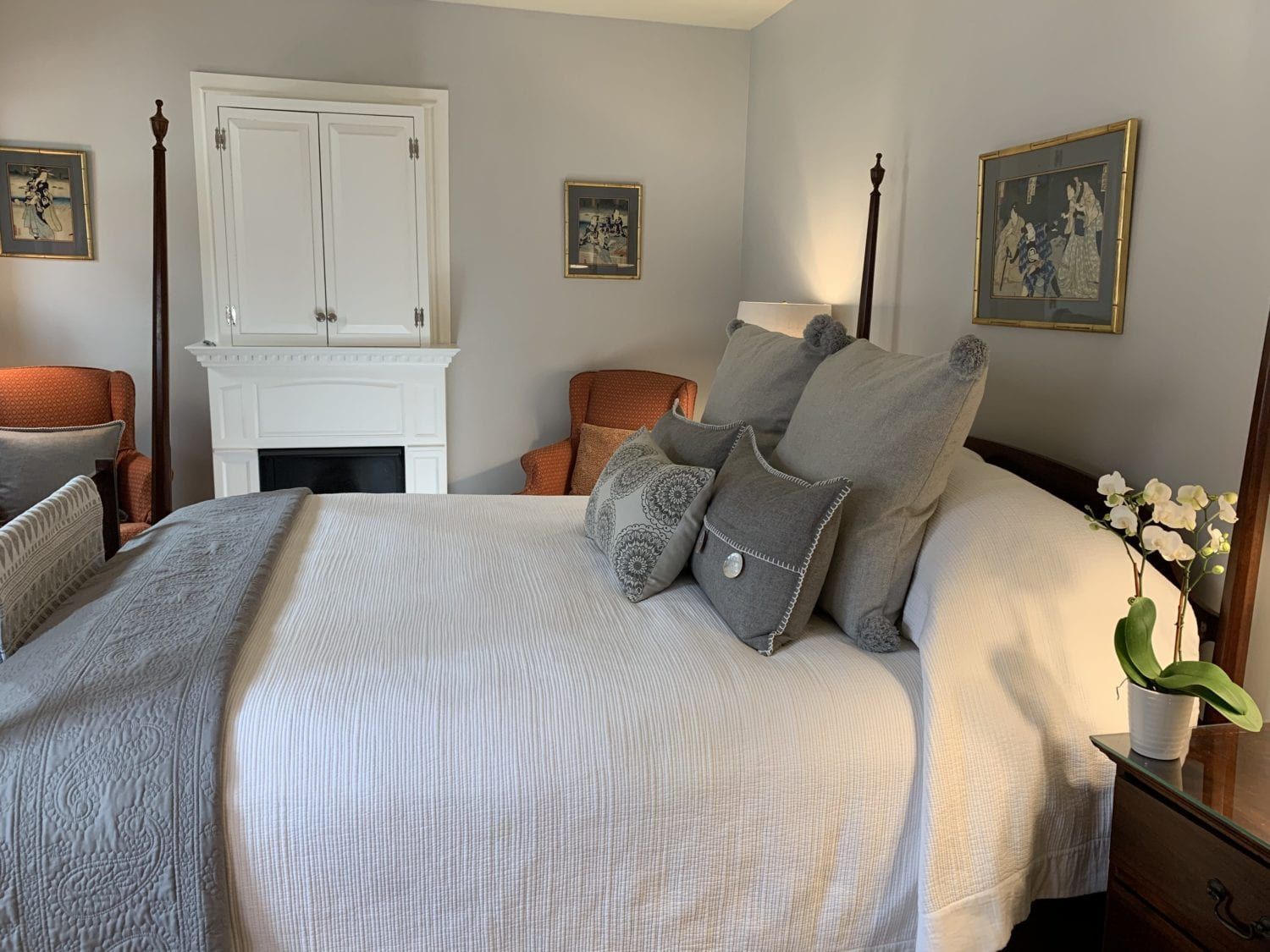 A bedroom with a large bed and a fireplace.