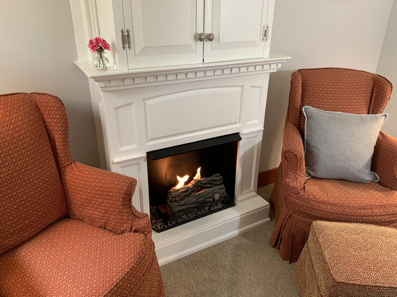 A living room with two chairs and a fireplace.