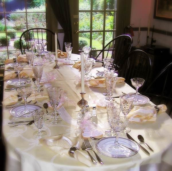 A long table with plates glasses and candles on it