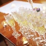 A row of champagne glasses sitting on top of a wooden table.