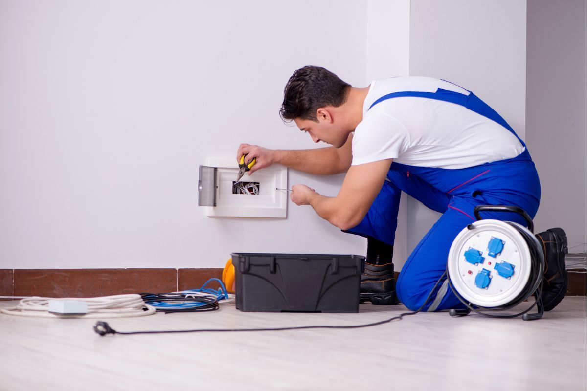 Electrician and customer in front of a white wall.