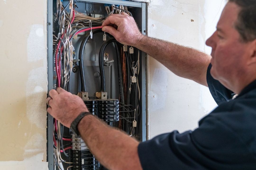 Electrician in front of a very neat breaker box.