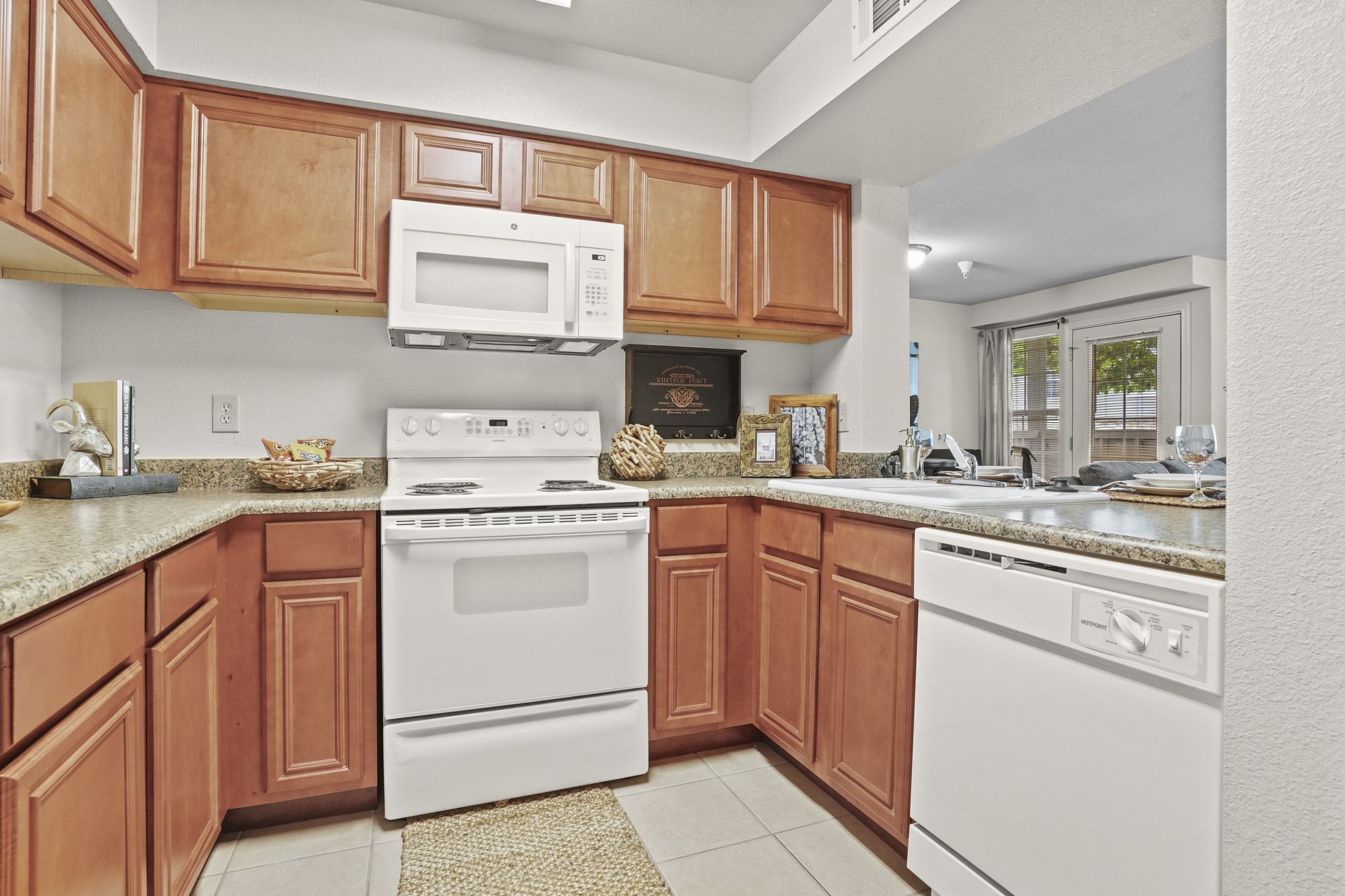 A kitchen with brown cabinets and white appliances.