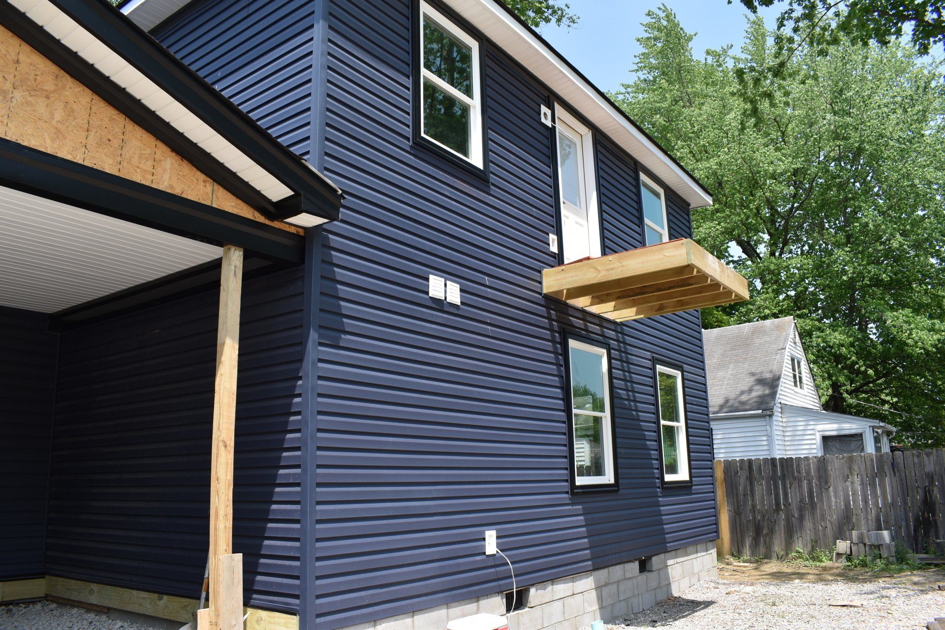 A house with a blue siding and white windows is being built.