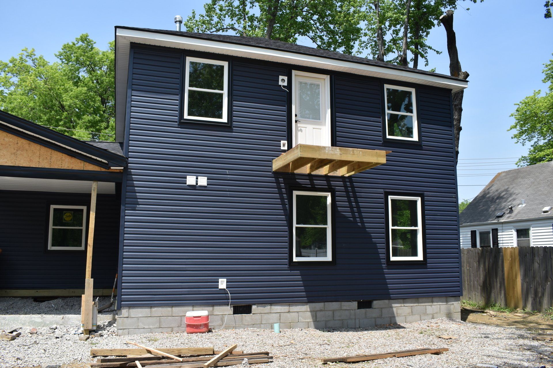 A blue house with a white door and windows is being built.
