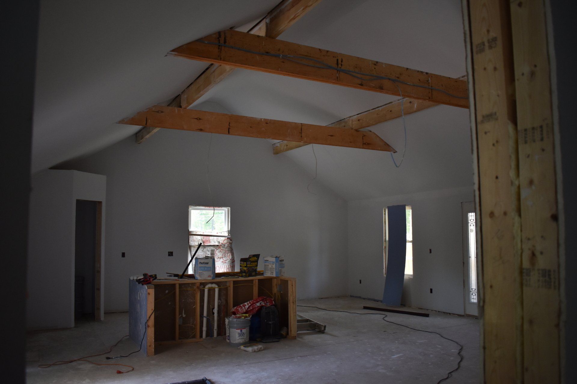 An empty room with wooden beams and white walls