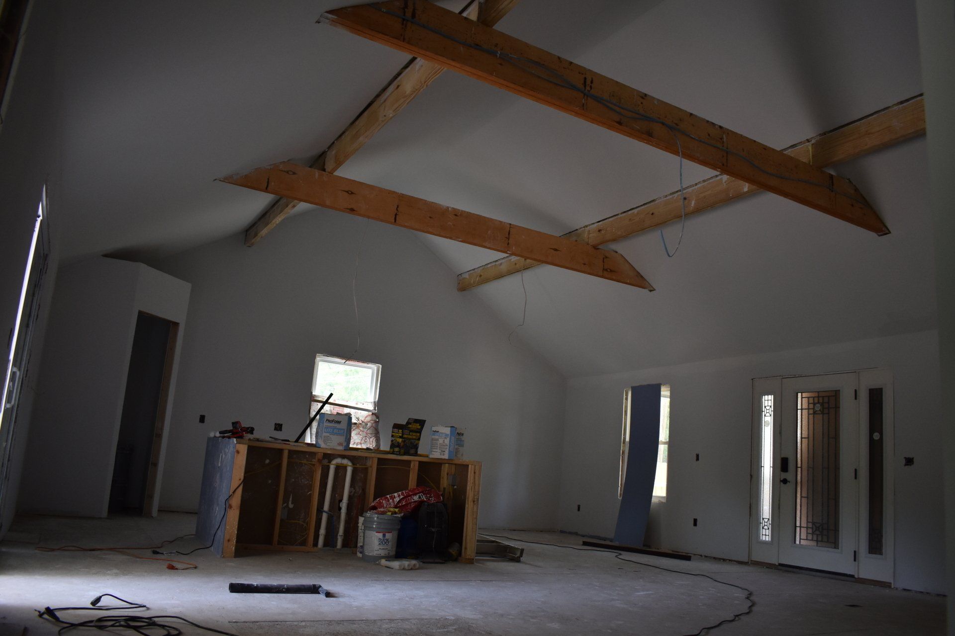 An empty room with a vaulted ceiling and wooden beams